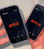 Two smartphones displaying the Netflix app on a light gray background