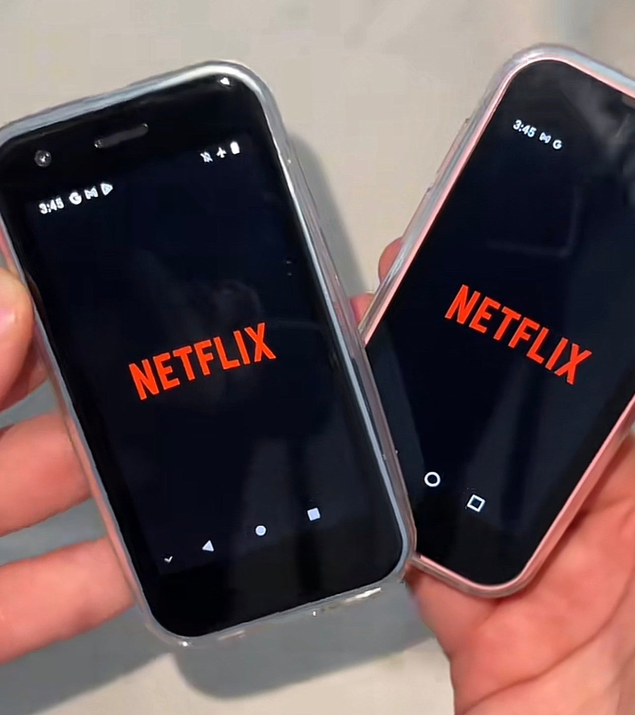 Two smartphones displaying the Netflix app on a light gray background